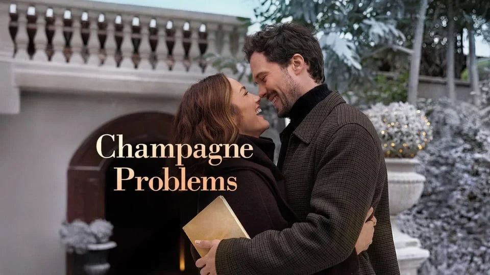Title logo for Champagne Problems featuring Minka Kelly and Tom Wozniczka embracing lovingly in a snowy courtyard.