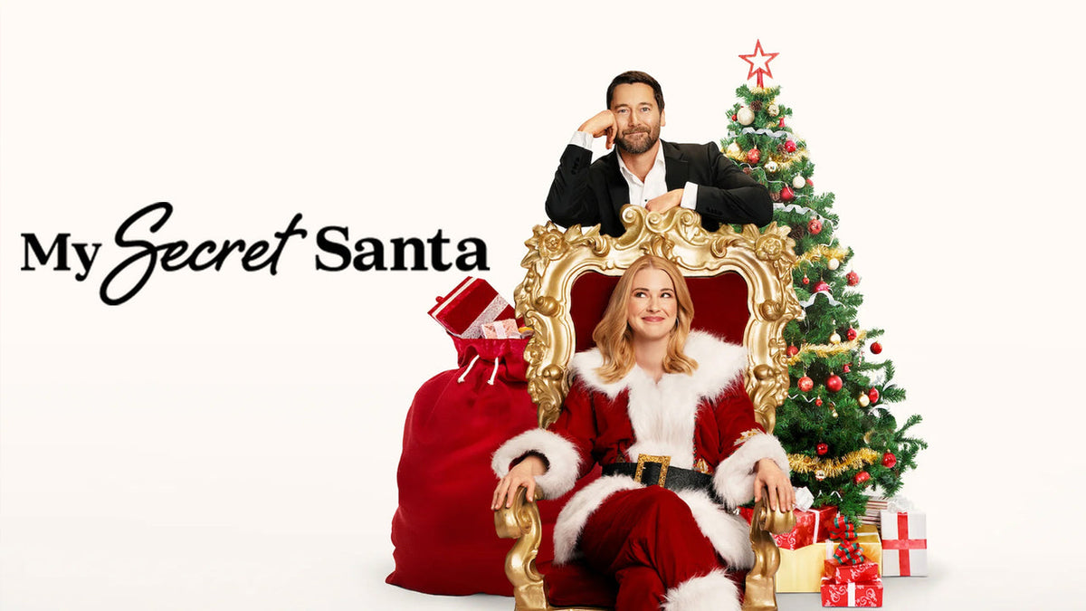 Official promotional graphic for My Secret Santa featuring Alexandra Breckenridge in a Santa suit on a throne next to Ryan Eggold and a decorated tree.