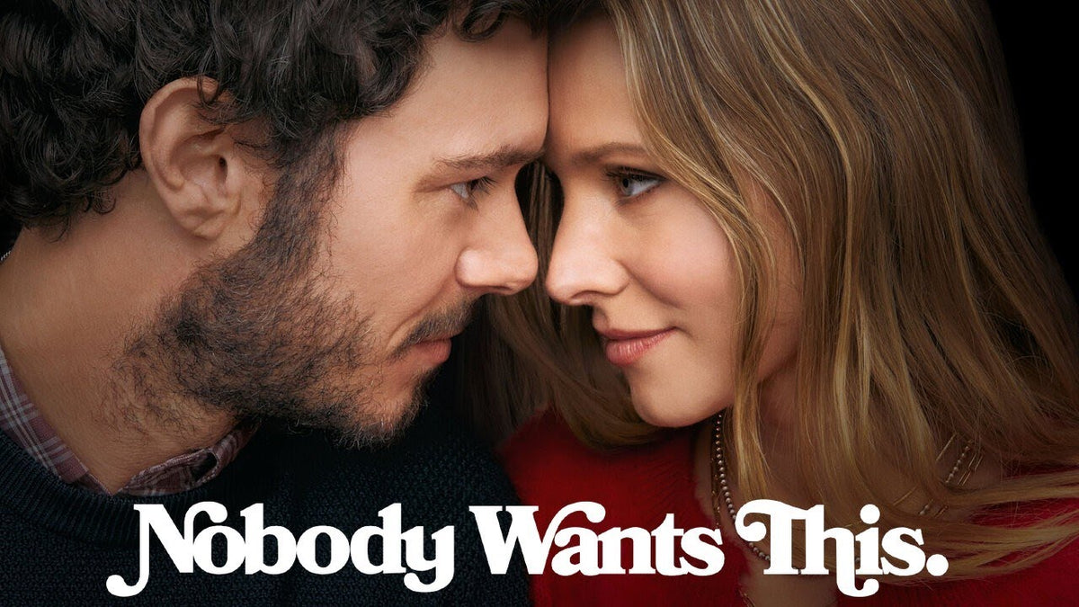 Extreme close-up shot of Adam Brody and Kristen Bell leaning forehead-to-forehead with the title text "Nobody Wants This" displayed along the bottom.
